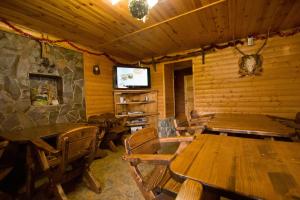 a dining room with wooden tables and a stone wall at Na Velykim in Yaremche