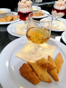 a white plate with a glass of wine and some desserts at Agriturismo Da Andreina in Borso del Grappa