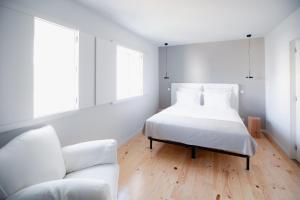 um quarto branco com uma cama e um sofá em Vila Real House em Vila Real