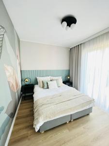 a bedroom with a bed and a large window at Apartament Sunnyside Rewa in Rewa