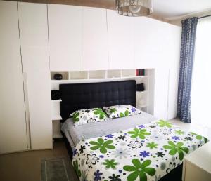 una camera con un letto e un piumone verde e bianco di Delizioso appartamento nel cuore Castelli Romani a Marino