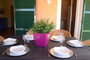 a table with plates and glasses and a vase on it at Villas Las Golondrinas in Cala'n Bosch