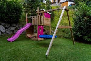 un parque infantil con un tobogán en un patio en Ferienwohnung Laura, en Wald am Arlberg