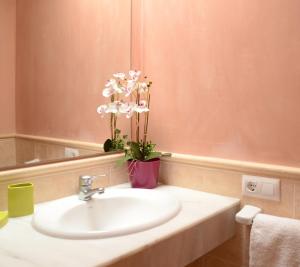 a bathroom with a sink and a mirror and flowers at Villas Las Golondrinas in Cala'n Bosch