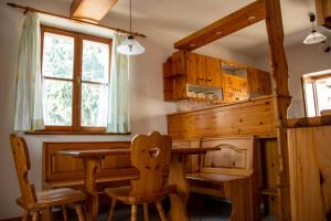 - une salle à manger avec une table et des chaises en bois dans l'établissement Apartma Na skdnu, à Dutovlje