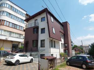 una macchina bianca parcheggiata di fronte a un edificio di Lovely Apartment Ioana a Târgu Neamț