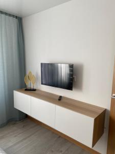 a living room with a tv on a white wall at AA Apartment in Ventspils