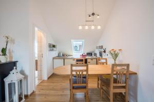 eine Küche und ein Esszimmer mit einem Holztisch und Stühlen in der Unterkunft Casa Lenny and Friends in Anzing