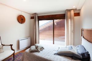 a bedroom with a bed and a large window at L'Audace in Mâcot La Plagne