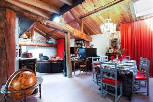 a dining room and living room with a red curtain at L'Audace in Mâcot La Plagne