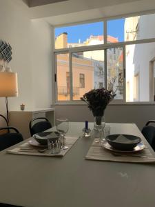 a table with two plates and glasses and a window at Charming apartment in Principle Real in Lisbon