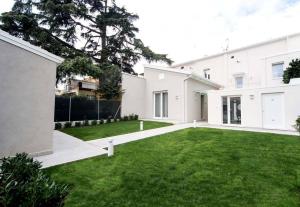 una gran casa blanca con un patio verde en Le Stanze Guesthouse, en Morciano di Romagna