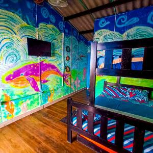 a room with a bunk bed and a mural at Hostal Liliana in Buenaventura