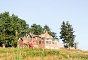 una casa grande en una colina en un campo en Serene 6BR country home on 325 acres ATV for rent, en Burgettstown