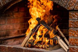a fire in a brick oven with flames at Vila Rustic INN Bucegi in Pietroşiţa
