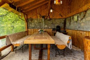 a dining room with a wooden table and benches at Vila Rustic INN Bucegi in Pietroşiţa