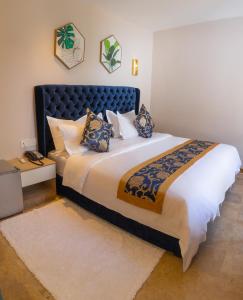 a bedroom with a large bed with a blue headboard at VANCII Hotel in Chefchaouene