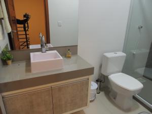 a bathroom with a sink and a toilet and a mirror at Casa de Praia em Torres RS Praia Lagoa jardim in Torres