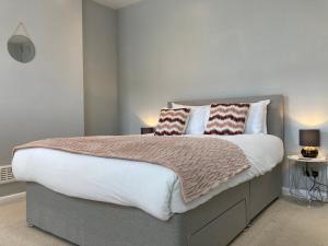 a bedroom with a large bed with two pillows on it at Tynwald Beachside Town House, West Kirby by Rework Accommodation in West Kirby