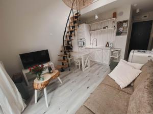 a living room with a couch and a table and a kitchen at Lovely apartment Nadolnik in Poznań