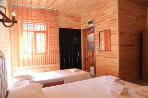 1 dormitorio con 2 camas en una habitación de madera en Olympos Robina Bungalov, en Olympos