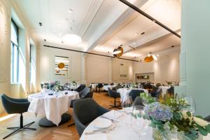 a restaurant with white tables and chairs and flowers at Hotel Kaiserhof Ravensburg in Ravensburg