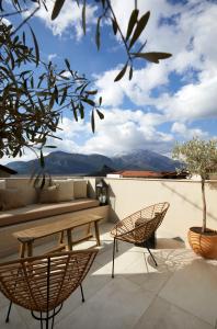 a patio with a bench and chairs on a roof at The Storyteller Boutique House in Kalabaka