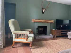 a living room with a chair and a fireplace at Achanlochan Farm in Taynuilt