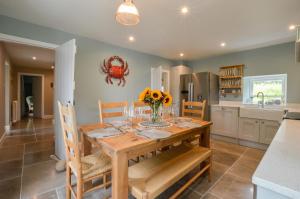 a kitchen and dining room with a wooden table and chairs at Achanlochan Farm in Taynuilt