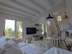 un salon avec un canapé et une télévision dans l'établissement Villa 'Andercool' avec piscine utilisable en toutes saisons, à Andernos-les-Bains