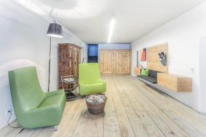 ein Wohnzimmer mit zwei grünen Stühlen und einem Sofa in der Unterkunft Exclusive Apartment Tassenbacherhof in Strassen