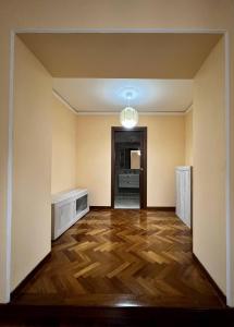 Cette chambre vide est dotée de parquet et d'un couloir. dans l'établissement Malies B&B, à Bénévent