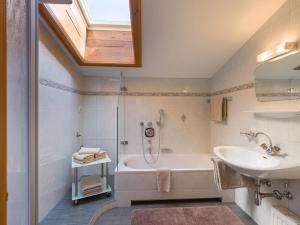 een badkamer met een wastafel, een bad en een wastafel bij Apartments Fleidl in Zell am Ziller