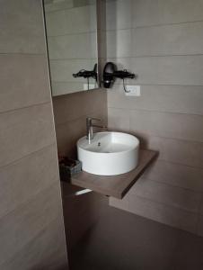 ein Badezimmer mit einem weißen Waschbecken und einem Spiegel in der Unterkunft U Ceccenate in Montalbano