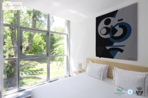 a white bedroom with a bed and a window at Boticas Hotel Art & SPA in Boticas