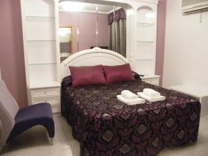 1 dormitorio con 1 cama con espejo y silla en Hostal Dulcinea, en Esquivias
