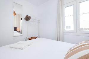 um quarto branco com uma cama branca e uma janela em San Jorge em Málaga