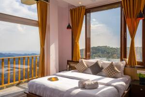 a bedroom with a bed with a large window at Zostel Banikhet (Dalhousie) in Dalhousie