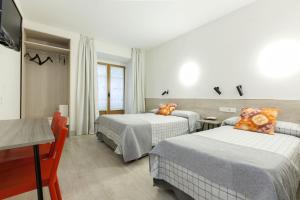 um quarto de hotel com duas camas e uma televisão em Hostal Castilla II Puerta del Sol em Madrid