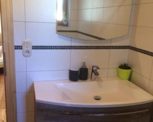 lavabo blanco en el baño con espejo en Biohof Höbarth en Sankt Martin