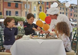a woman serving food to two children at a table at Splendido, A Belmond Hotel, Portofino in Portofino