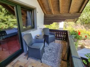 eine Terrasse mit Stühlen und einem Tisch auf dem Balkon in der Unterkunft B&B Am Sahrbach in Altenahr