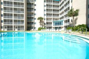 a large swimming pool with buildings in the background at Holiday Surf and Racquet Club 319 in Destin