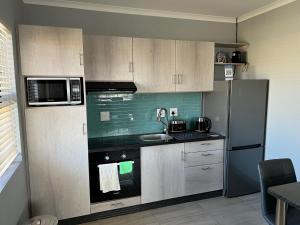 Elephant House, 2 bedroom House, Next to Pilanesberg and Sun City في Mogwase: مطبخ مع ثلاجة وموقد فرن علوي