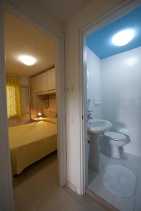 a bathroom with a bed and a toilet and a sink at Residence Le Orchidee in Vieste