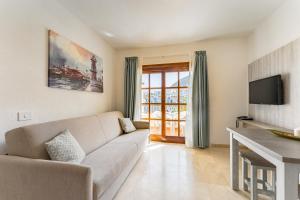 a living room with a couch and a tv at Klayman Olivina Aparthotel in Los Cristianos