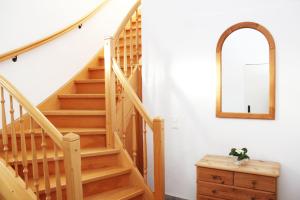 escalera de madera en una habitación blanca con espejo en Ferienwohnung Möller - a64524, 