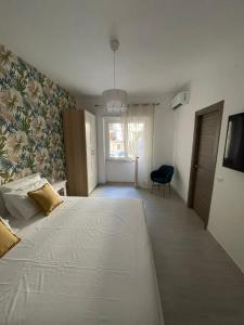 una camera con un grande letto bianco e una sedia di Anfra B&B a Napoli