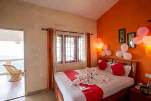 a bedroom with a bed with pink balloons on it at Syamantac Villa in Kodaikānāl