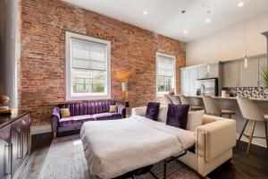 1 dormitorio con cama y pared de ladrillo en The Endymion en Nueva Orleans